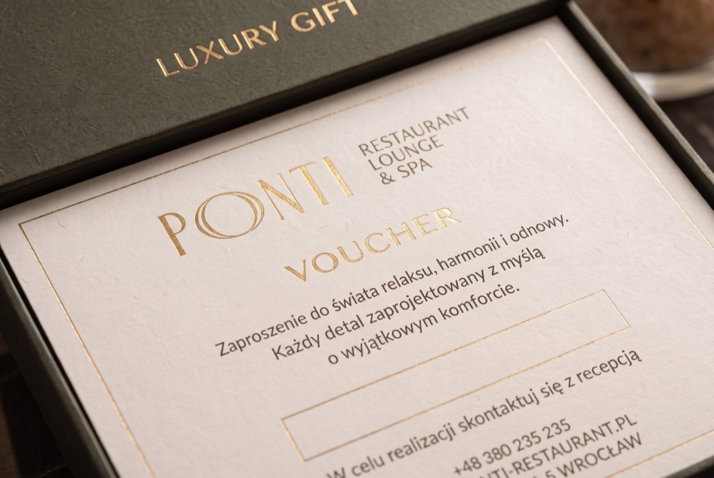 Zbliżenie na złocony nadruk karty vouchera PONTI